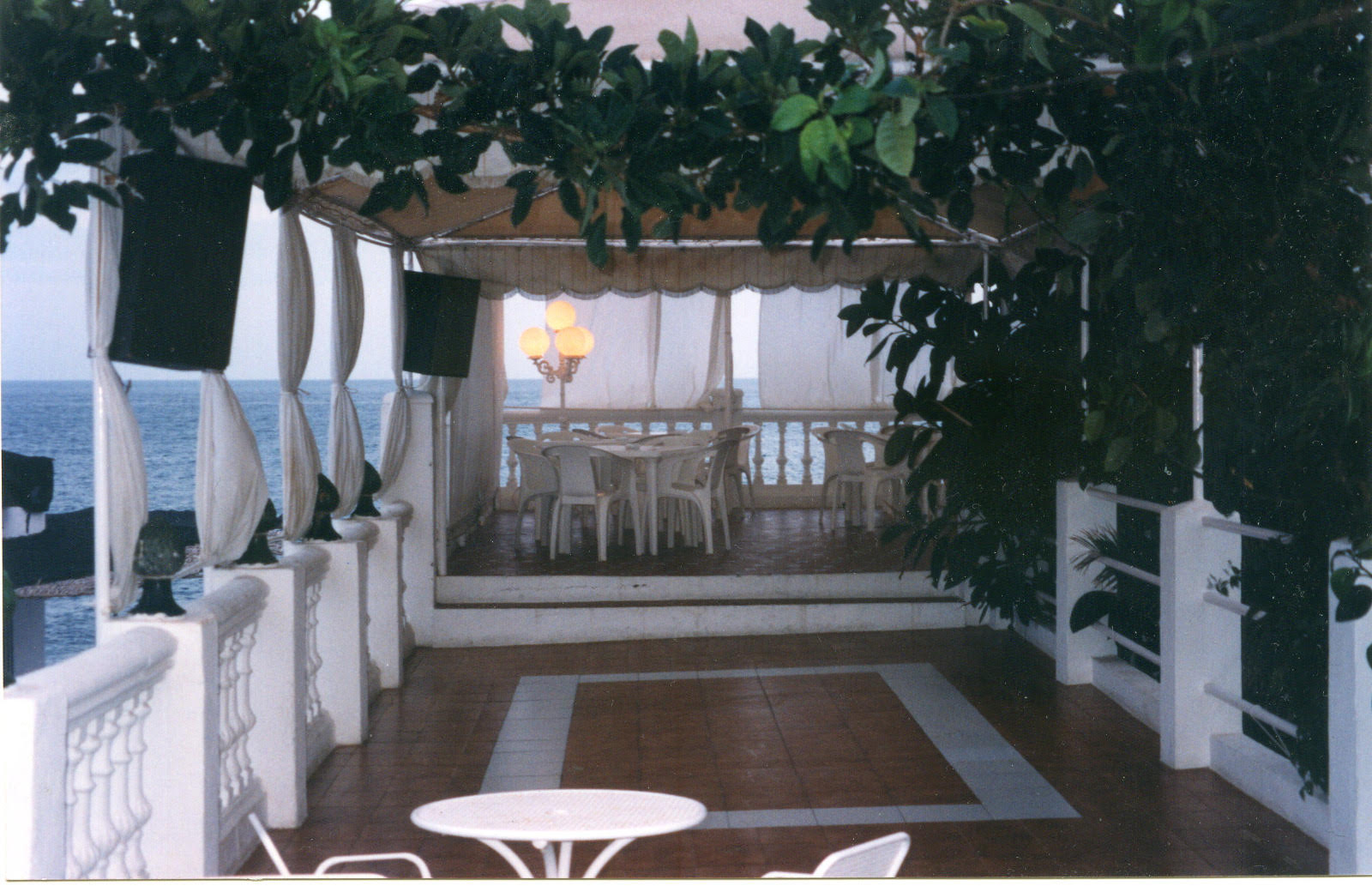 Covered seaside terrace with curtains and sea view